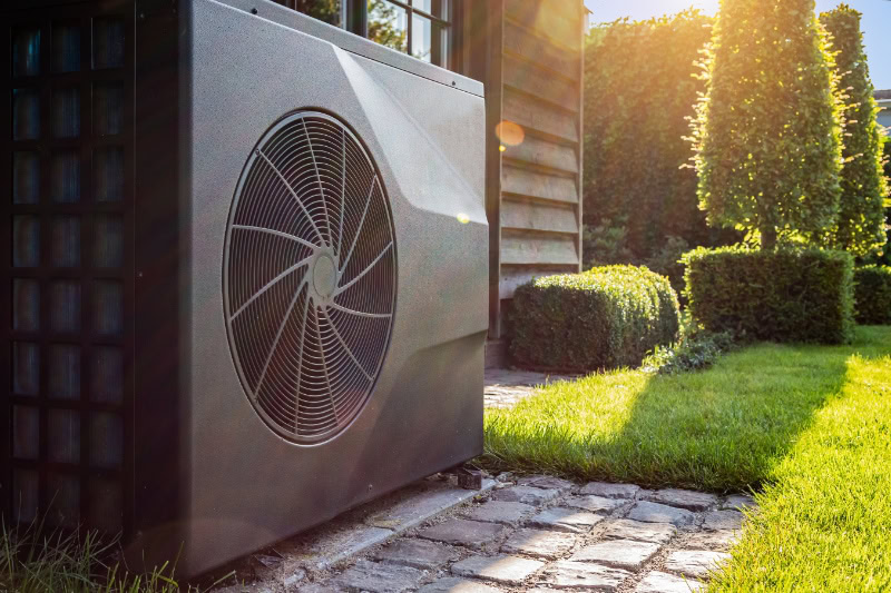 Transitioning Your Heat Pump. Close-up of black full inverter heat pump outside in the garden